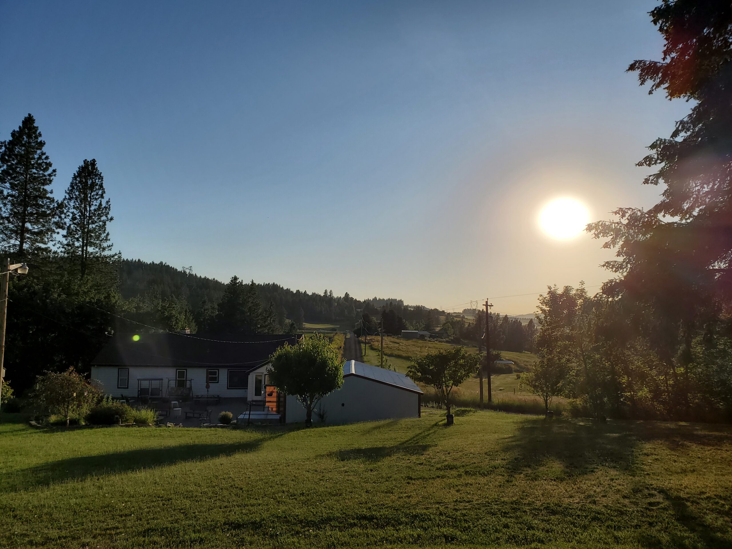 Sun shining over country home.